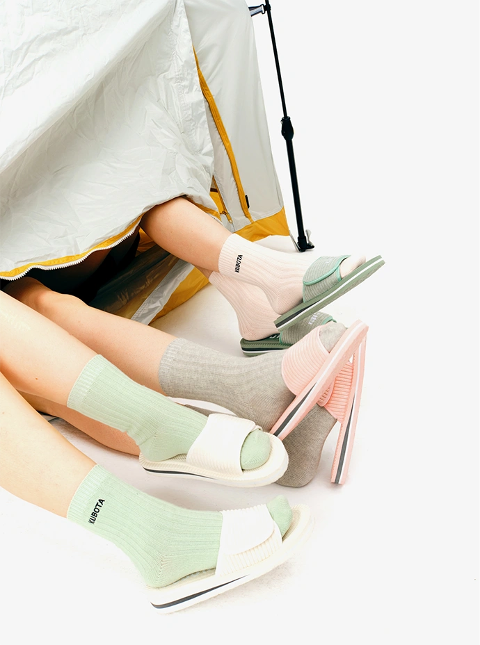 Zdjęcie lookbookowe prezentujące stylizacje z damskimi klapkami sztruksowymi i prążkowanymi skarpetkami Kubota w różnych kolorach. Produkty z kolekcji jesień/zima 2025.