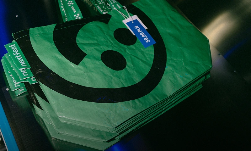 Baner podstrony Kubota na NEXT FEST. Zielone shopperki festiwalowe z oficjalnym logo NEXT FEST z limitowanego merchu.