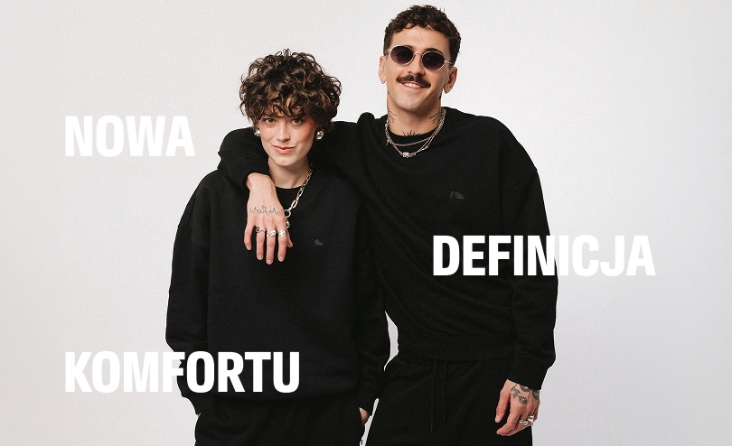 Zdjęcie lookbookowe kobiety i mężczyzny w czarnych dresach Kubota. Grafika z białym napisem "Nowa definicja komfortu", wprowadzająca w klimat kategorii Moda wiosna lato 2026.