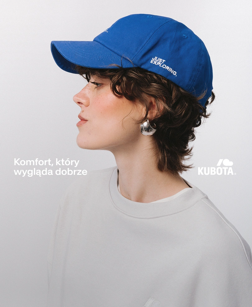 Zdjęcie lookbookowe modelki z profilu, ubranej w kobaltową czapkę z daszkiem Street Edge oraz szarą bluzę Easy. Grafika zawiera logo Kuboty oraz hasło "Komfort, który wygląda dobrze", wprowadzając w klimat kategorii Moda wiosna lato 2026."